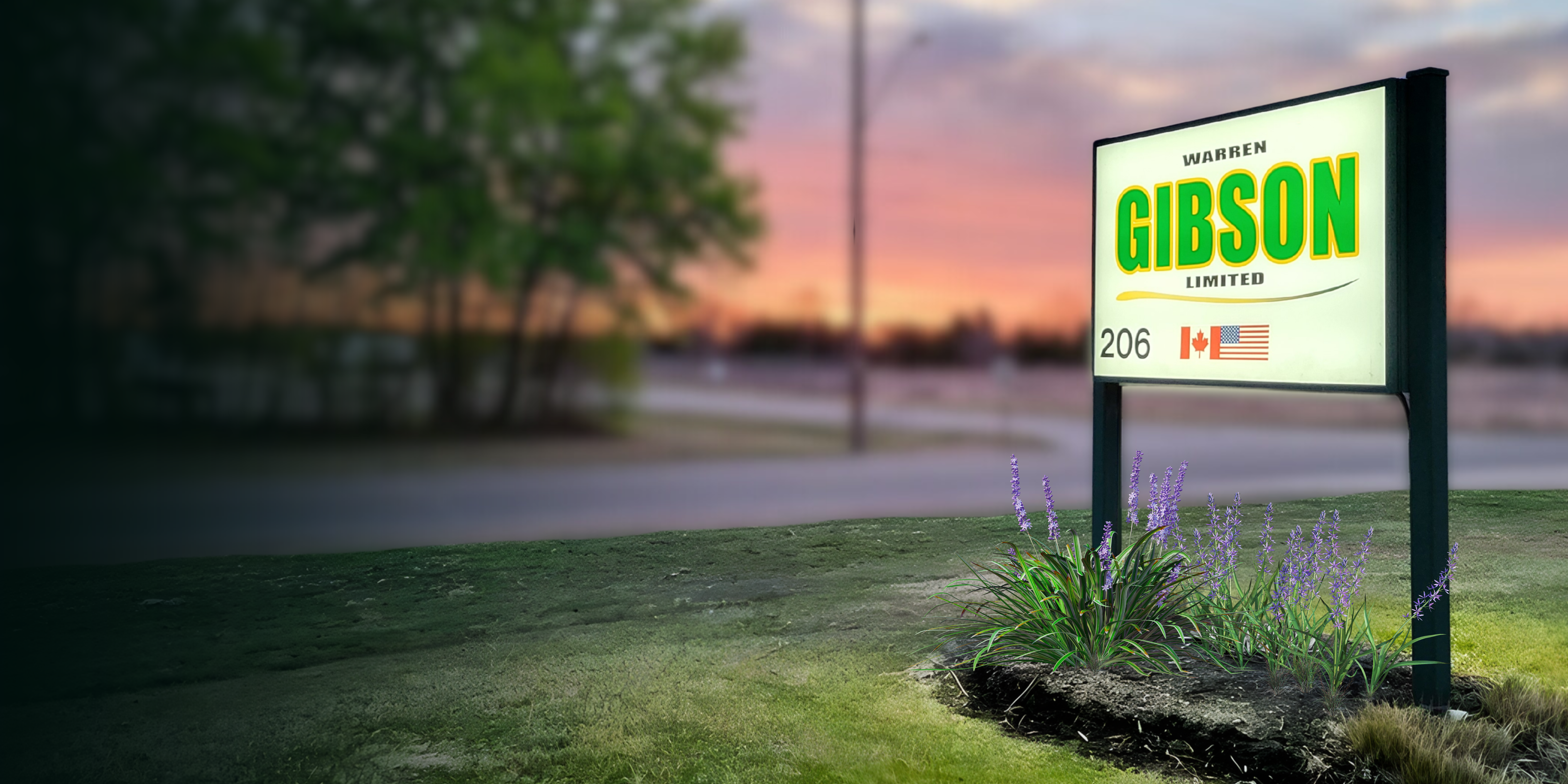 Welcoming entrance sign with flower bed and inviting sunset placed at entrance of Warren Gibson Limited.